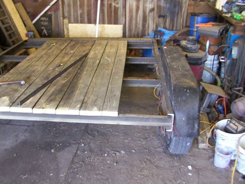 1900 Ford C-350 (Centurion Conversions) - Trailer frame with wooden deck, partially constructed in a workshop setting.