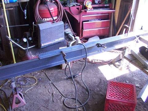 1900 Ford C-350 (Centurion Conversions) - Workshop scene with metal beam, air compressor, and tools, likely for fabrication or repair.