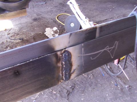 1900 Ford C-350 (Centurion Conversions) - A close-up view of a metal frame being welded, with a grinder and chalk markings visible.