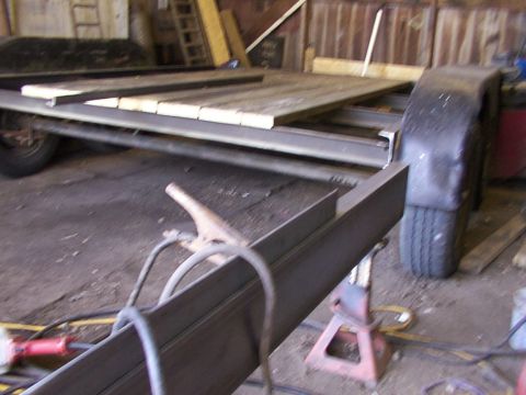 1900 Ford C-350 (Centurion Conversions) - Trailer frame construction in progress with wooden planks and welding gear.