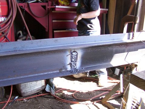 1900 Ford C-350 (Centurion Conversions) - Steel beam undergoing welding repairs in a workshop environment.