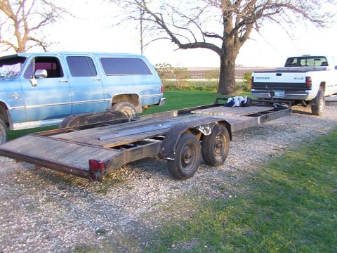 1900 Ford C-350 (Centurion Conversions) - Blue SUV and white Dodge pickup truck are parked with a car hauler trailer.