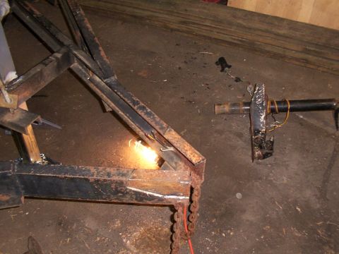 1900 Ford C-350 (Centurion Conversions) - A close-up view of metal fabrication work, with welding in progress on a complex frame structure.