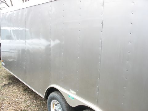 1900 Ford C-350 (Centurion Conversions) - This is a side view of a silver enclosed trailer with visible rivets and a wheel.