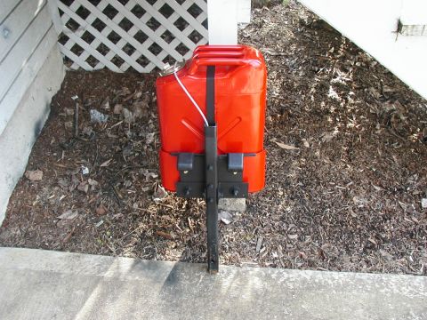 1995 Ford Bronco - A red jerry can is mounted to a black bracket, likely for external storage on a vehicle.