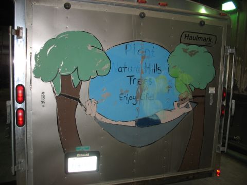 1900 Ford C-350 (Centurion Conversions) - Haulmark trailer features a painted mural with trees and a person relaxing in a hammock.