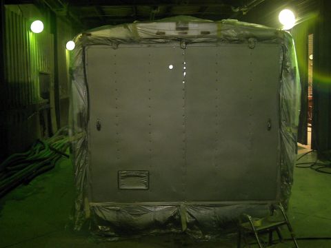 1900 Ford C-350 (Centurion Conversions) - Rear view of a vehicle's enclosed cargo area, covered in protective plastic sheeting.