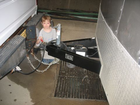 1900 Ford C-350 (Centurion Conversions) - Child operates the trailer hitch mechanism connected to a white truck.