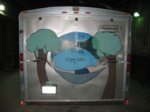 1900 Ford C-350 (Centurion Conversions) - This enclosed trailer features a mural with the text "Plant Trees Enjoy Life!" and a person relaxing in a hammock.