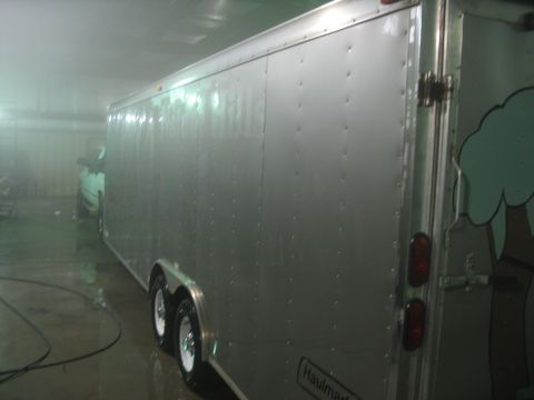 1900 Ford C-350 (Centurion Conversions) - An enclosed trailer is parked inside a misty area, with another vehicle partially visible within.