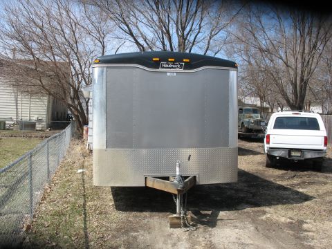 1900 Ford C-350 (Centurion Conversions) - A silver enclosed trailer is parked in a yard with a white pickup truck and an older vehicle visible in the background.