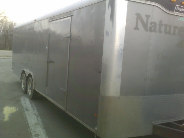 Enclosed cargo trailer with 'Nature' text on the side