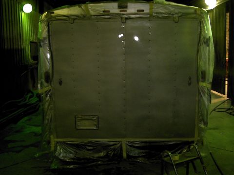 1900 Ford C-350 (Centurion Conversions) - The rear doors of a trailer are covered in plastic sheeting, likely for protection or preparation for work.