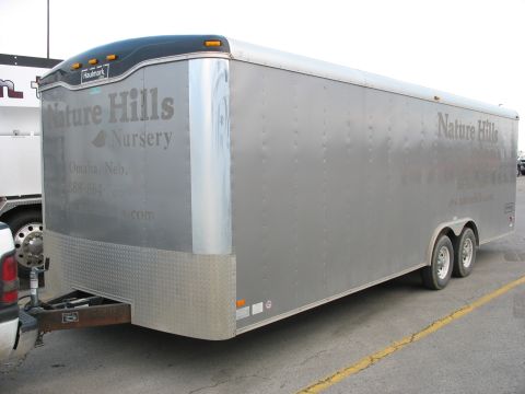 1900 Ford C-350 (Centurion Conversions) - A silver enclosed trailer with 'Nature Hills Nursery' branding is visible from a side angle.