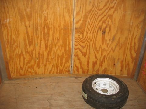1900 Ford C-350 (Centurion Conversions) - A spare tire rests on the wooden floor of a trailer.
