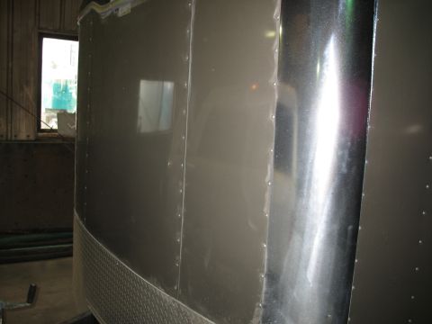 1900 Ford C-350 (Centurion Conversions) - The exterior of a trailer is shown, riveted panels and a diamond plate lower section.