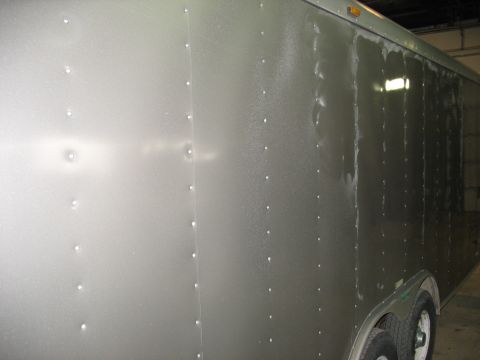 1900 Ford C-350 (Centurion Conversions) - Side view of a silver enclosed trailer with visible rivets and wheels.