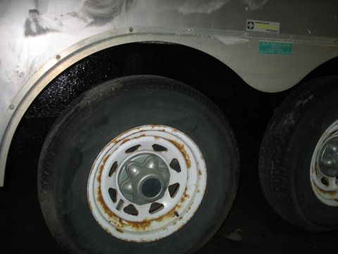 1900 Ford C-350 (Centurion Conversions) - Dual trailer wheels and fender detail, showing some rust on the rims and a sticker on the trailer body.