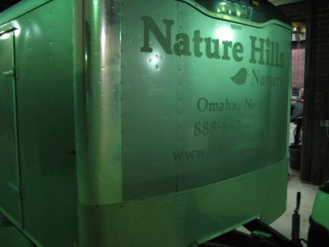 1900 Ford C-350 (Centurion Conversions) - The side of an enclosed trailer displays the Nature Hills Nursery logo and contact information.