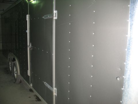 1900 Ford C-350 (Centurion Conversions) - This is a side view of a dark gray enclosed cargo trailer with visible rivets and hinges on its doors.