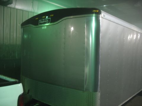 1900 Ford C-350 (Centurion Conversions) - A silver Haulmark trailer is shown from the front-side angle, parked indoors.