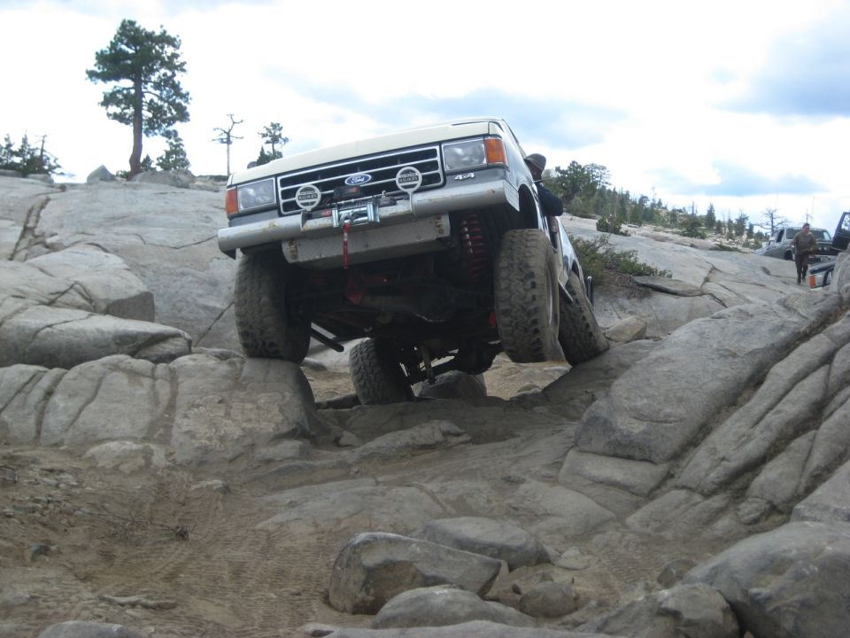 White 1991 Ford Bronco climbing rocks