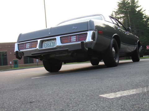 2001 Ford Crown Victoria - Rear view of a dark gray Dodge sedan with a chrome bumper and horizontal taillights.