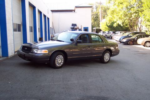 2001 Ford Crown Victoria - This 2001 Ford Crown Victoria is seen parked in front of a commercial building with other vehicles in the background.