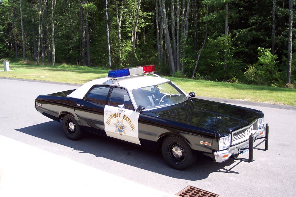 Black and white police car with "HIGHWAY PATROL" on the side and a light bar on top