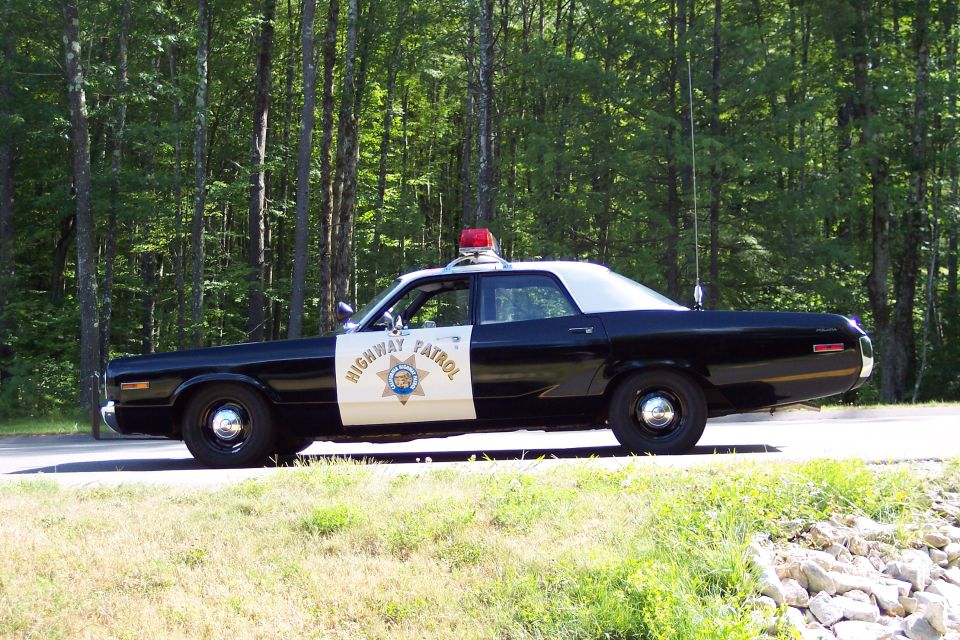 Side view of a black and white highway patrol car with "HIGHWAY PATROL" text on the door