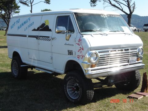 1993 Ford Bronco - This custom van features a lifted suspension, off-road tires, and unique graphics, including a mountain scene and checkered flag pattern.