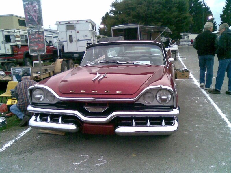 Red 1957 Dodge Custom Royal convertible with chrome grille and dual headlights, viewed from the front
