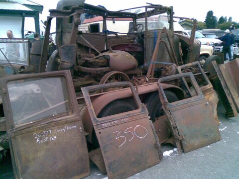 1969 Lincoln Continental - Scrap metal and parts from old vehicles are displayed, with some doors having handwritten labels and prices.