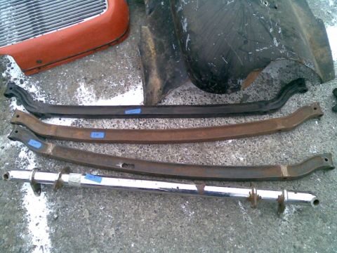 1969 Lincoln Continental - Various car suspension components and a partial grille are laid out on a concrete surface.