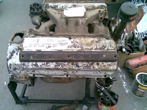 1969 Lincoln Continental - A weathered V8 engine, possibly a HEMI, is displayed on a stand with some parts nearby.