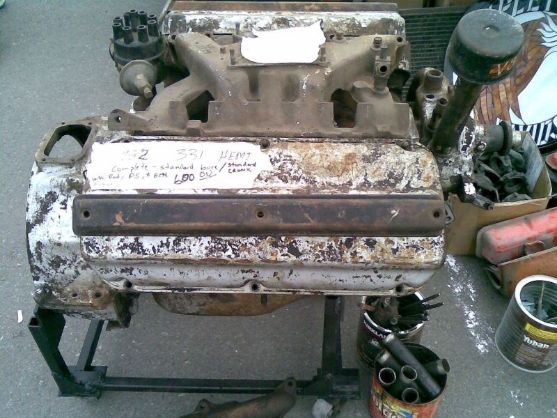 Old V8 engine on a stand, has a label that says "331 HEMI"