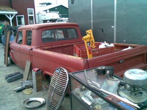 1969 Lincoln Continental - A red pickup truck is parked with various car parts displayed around it.
