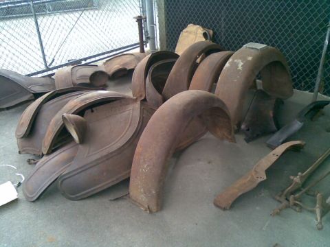 1969 Lincoln Continental - Collection of old, weathered car fenders and parts, likely for restoration.