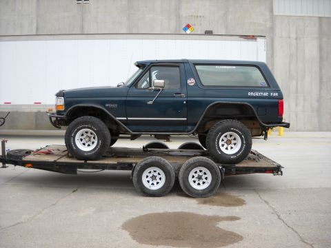 1900 Ford C-350 (Centurion Conversions) - Ford Bronco loaded onto a trailer, side profile. Text 'ROCKSTAR FAR' visible on the rear window.