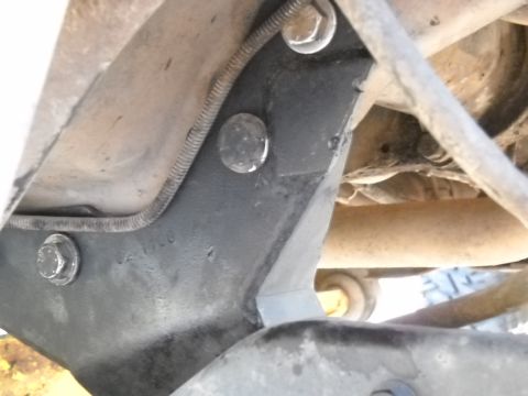 1996 Ford F-250 - Detail of a truck's frame bracket with a bolted connection and wire conduit visible.