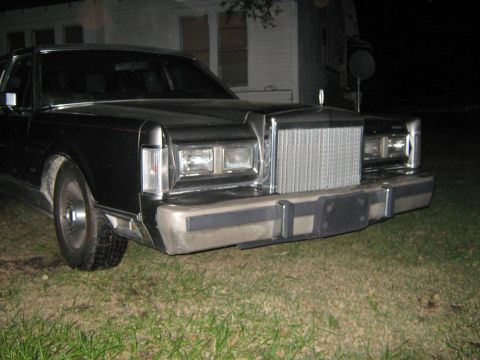 2000 Mercury Grand Marquis - The front grille and headlights of a Lincoln Town Car are visible in this nighttime photo.
