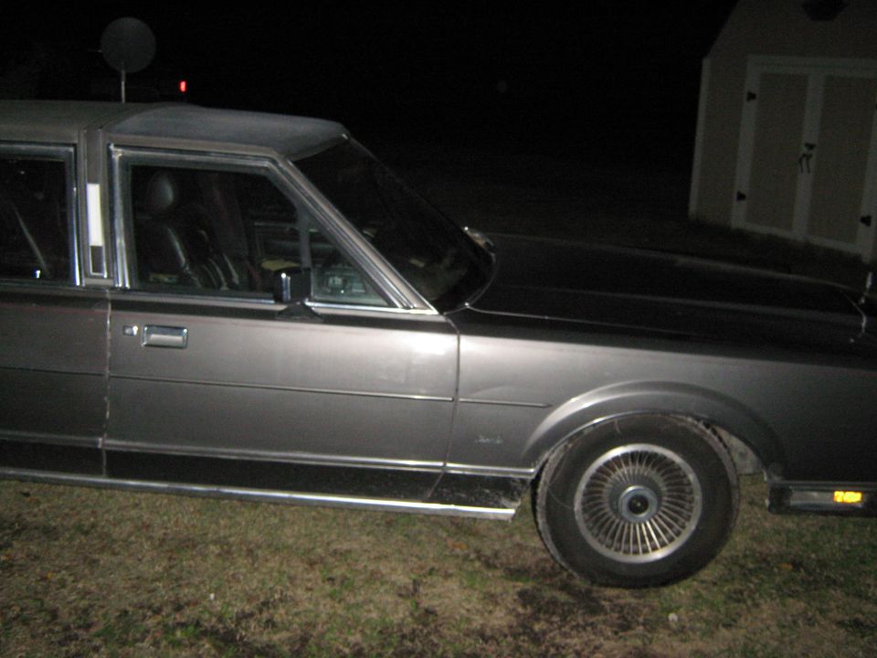 1980s Lincoln Town Car side view, dark exterior, parked at night