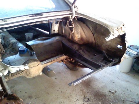 1969 Ford Mustang - Work is underway on the trunk floor and rear quarter panel of a classic vehicle, showing structural repairs.