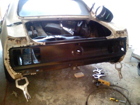 1969 Ford Mustang - Rear end of a 1969 Ford Mustang undergoing body repair, with tools visible.