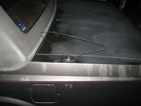 2000 Mercury Grand Marquis - Wire coat hanger on a car's trunk lid, with a fuel door visible below.