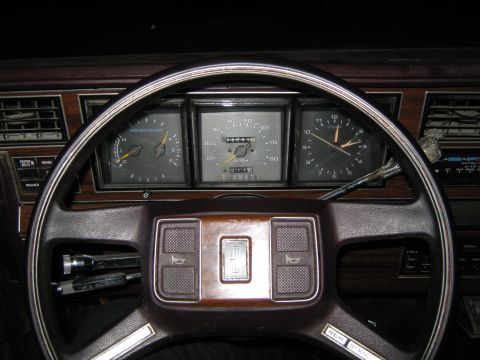 2000 Mercury Grand Marquis - Dashboard interior with odometer reading 07551 and clock. Wood grain trim is visible.
