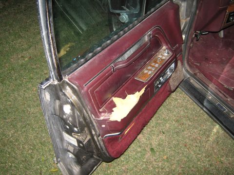 2000 Mercury Grand Marquis - The interior door panel shows significant wear, with peeling trim and worn upholstery.