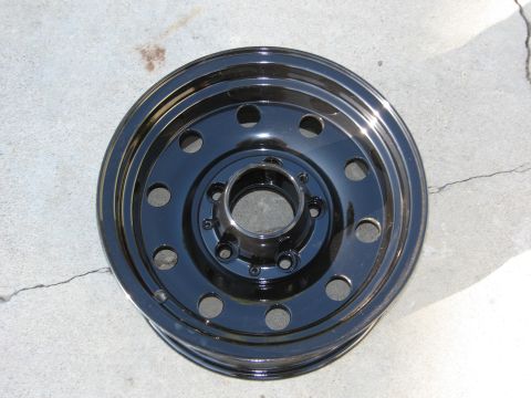 1986 Ford Bronco - A single black steel wheel is shown resting on a concrete surface.