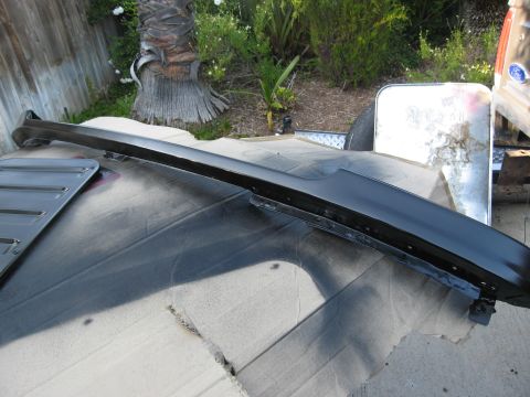 1986 Ford Bronco - A black dashboard trim piece is shown laid out on cardboard, possibly for restoration or repair.