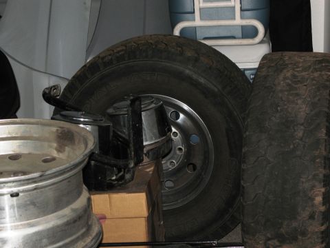 1986 Ford Bronco - A spare tire and wheel assembly are stored, along with other items, inside a vehicle.